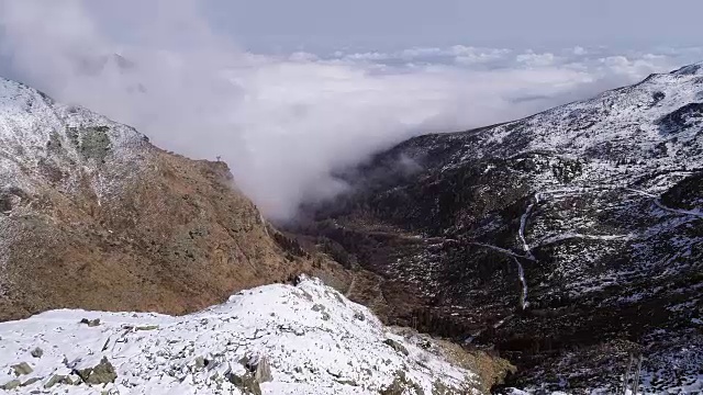 空中飞行向前移动的雪山山脊山谷与云彩和太阳建立。冬季户外雪高山野自然景观。4k无人机飞行建立镜头视频素材