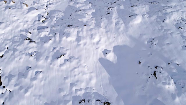 高空飞过雪山，山脊，山谷建立者向前飞行。户外雪高山野生自然景观在冬季顶视图与阳光和阴影。4k无人机飞行建立镜头视频素材