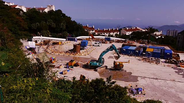 在香港山顶的建筑工地，挖掘机吊运重型机械及驾驶视频素材