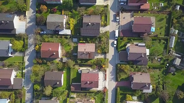 秋日，在宁静的郊区小镇阳光明媚的屋顶上飞翔视频素材