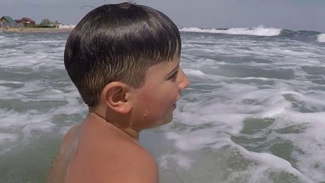 那男孩在海里溅起泡沫视频素材