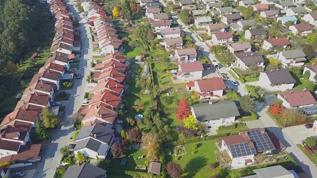 航拍:在田园诗般的郊区小镇上空飞行，那里有排屋和绿色花园视频素材