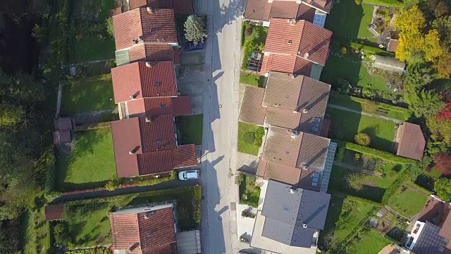 空中俯瞰在有排屋和绿色花园草坪的郊区城镇上空飞行视频素材