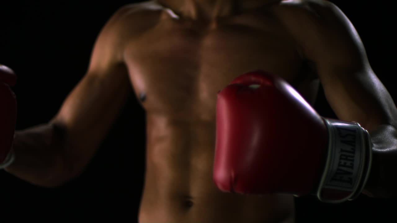 SLO MO CU工作室拍摄的赤膊男子戴拳击手套，中间部分视频下载
