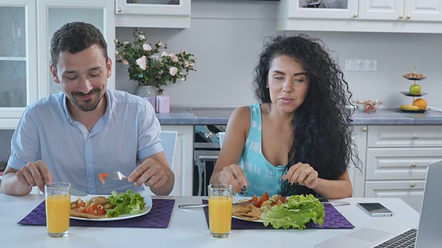 一对美丽的夫妇在厨房吃早餐视频素材