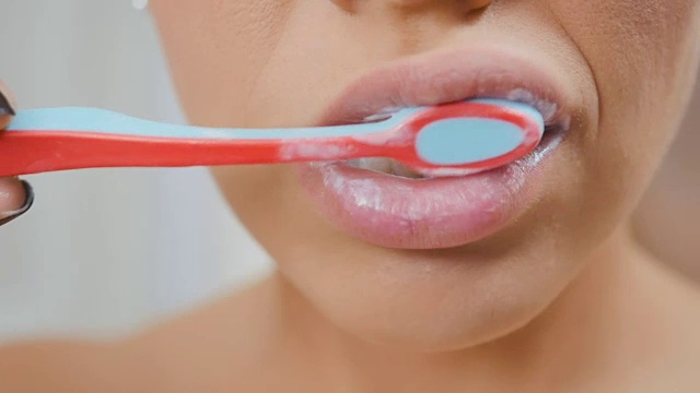 女人用牙膏和牙刷清洁牙齿视频素材