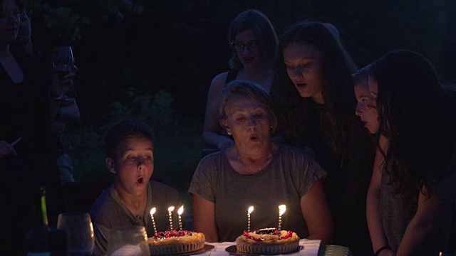 祖母生日聚会，晚上有蛋糕和蜡烛的户外大家庭视频下载