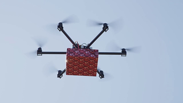 LENS FLARE:无人机在晴朗的蓝天上运送圣诞礼物视频下载