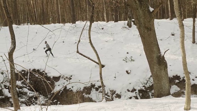 年轻的运动员在冬天的森林里跑步视频素材