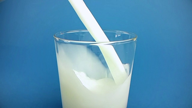 鲜白牛奶倒入杯中，色键蓝屏背景，慢镜头拍摄，饮食和健康营养视频素材