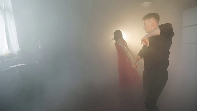 一对聪明的夫妇在烟雾中表演美丽的探戈。视频素材