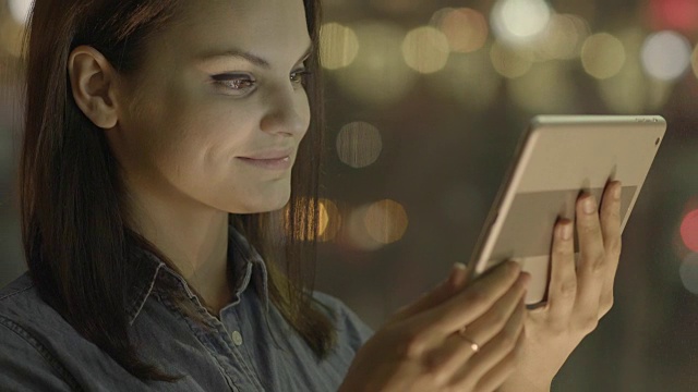美女发短信和上网与数字平板电脑。深色头发的女人用便携式设备在公共空间保持联系。视频素材