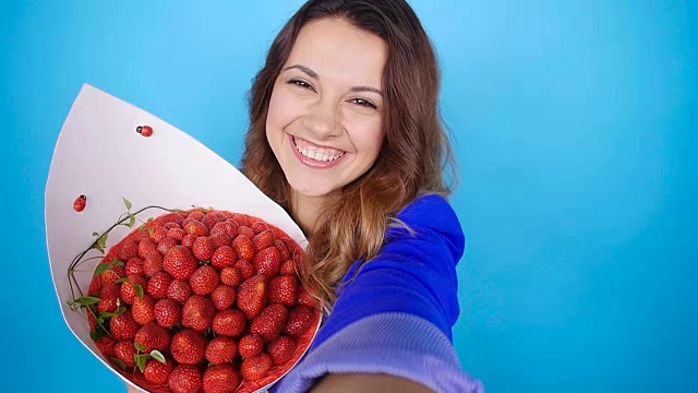 一名年轻女子拿着一束草莓拍照视频下载
