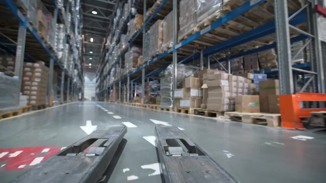 叉车在现代仓库的大型金属货架之间移动视频素材