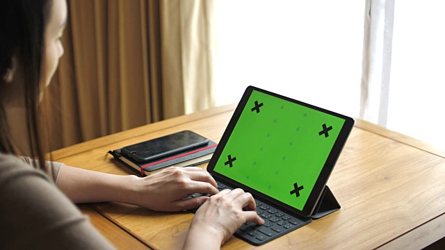 在家里使用绿色屏幕的平板电脑，水平视频素材