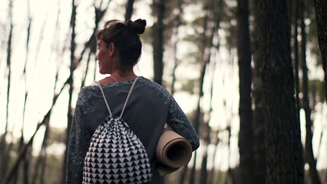 美丽的中年女人与瑜伽马特走在松林在法国南部。视频下载