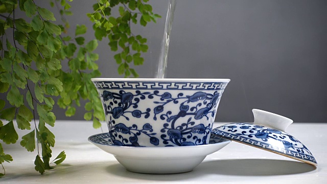 热水倒入中国传统茶杯视频素材