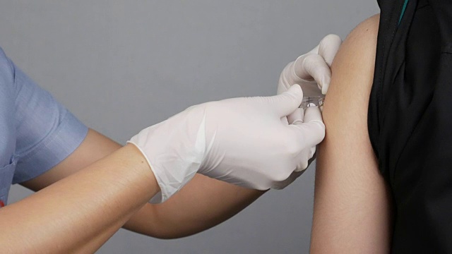医生在病人的手臂上注射流感疫苗视频素材