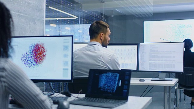 多民族计算机科学家团队在他们的工作站创建神经网络。办公室充满了显示神经网络的3D表示。视频素材
