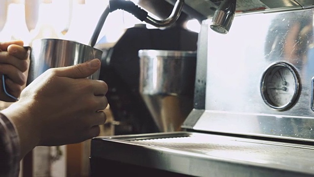 咖啡师在金属罐子里蒸牛奶视频素材