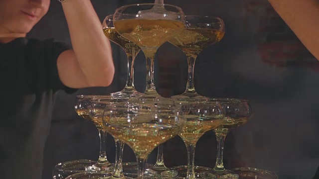 侍者倒香槟在杯子在金字塔的慢动作，特写视频素材