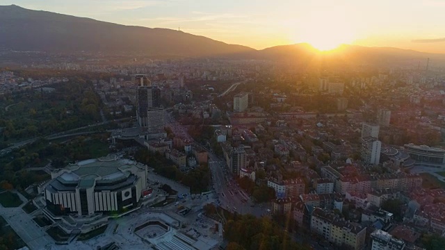 华丽的电影宽镜头的无人机飞过大城市和朝着夕阳视频下载