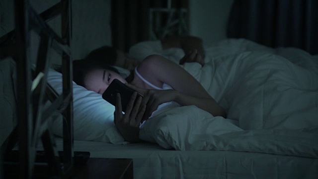 女人在床上用智能手机拍多莉视频下载