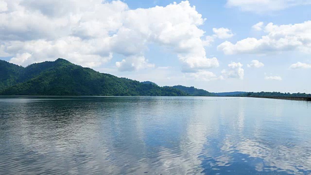 宁静的湖景和多云的天空和绿色的山背景视频素材