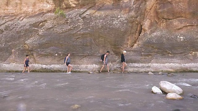 4K超高清:年轻人徒步穿越河流视频素材