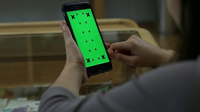 男性手持绿色屏幕智能手机的特写视频素材