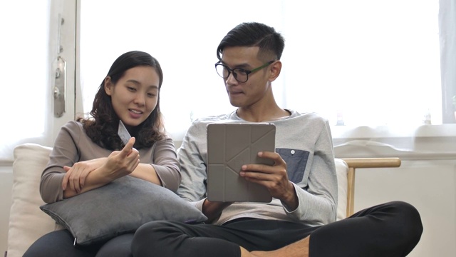 青年男女在数字平板电脑上用信用卡在线购物视频素材