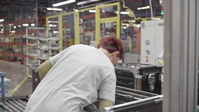 工厂工人在他们的工作岗位上检查半成品视频下载