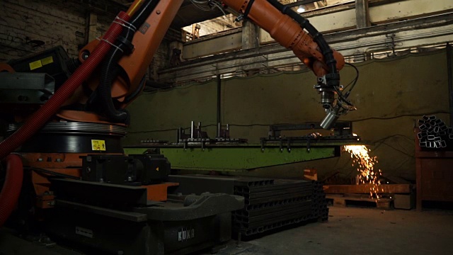 工业机器人工作原理。在工厂切割金属板材。重工业中的现代工具。有火花的危险工作。在室内自动化过程。视频素材