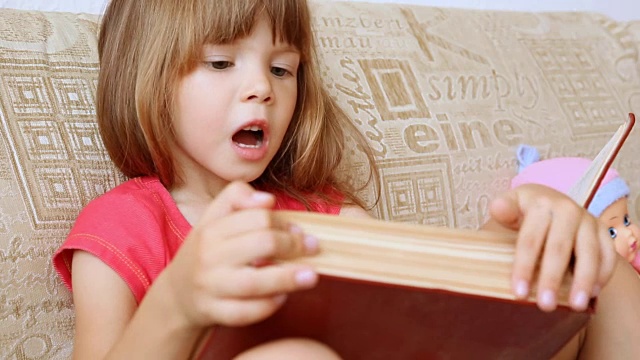 小女孩在读一本大书视频素材