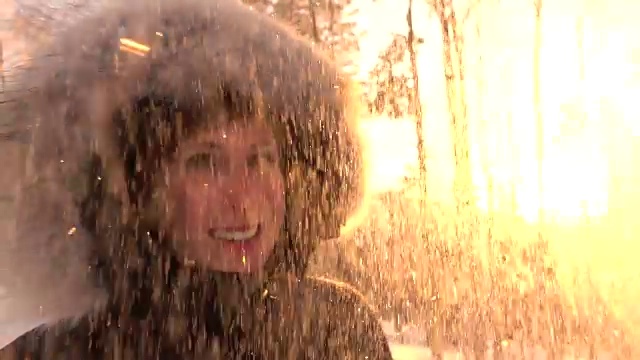 慢镜头晶莹的雪花在冬天飘落在幸福微笑的少女身上视频素材