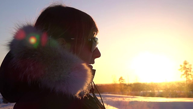 在冬季徒步旅行的女人在日落时呼吸着从嘴里冒出来的蒸汽视频下载