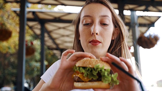 非常饿的女人在咬她的汉堡视频下载
