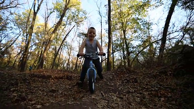 小男孩在大自然中骑自行车视频素材