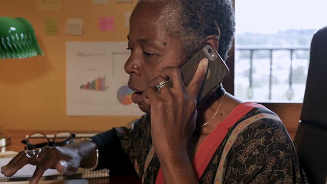 慢慢推出黑人女性在家庭办公室用智能电话技术说话视频素材