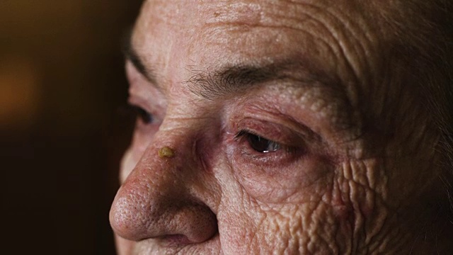 在老妇人的眼睛上的特写肖像:悲伤的老妇人的肖像视频素材