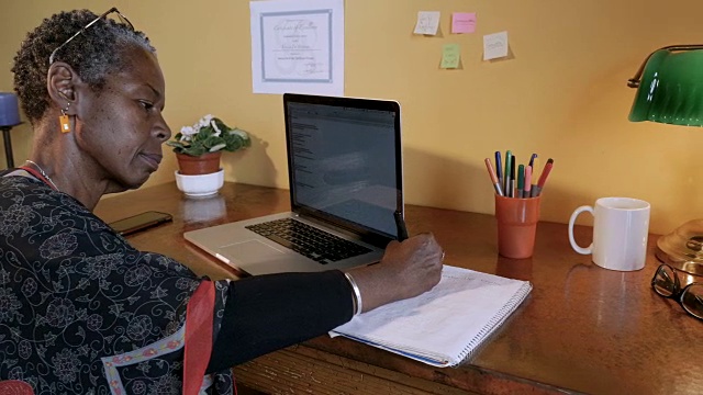 有魅力的成功非洲裔美国女人在她的书桌写作视频素材
