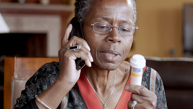 快乐的非裔美国老年妇女打电话到药房拿处方视频素材
