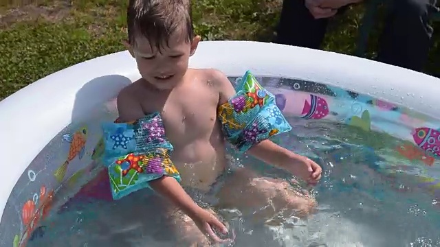 小男孩在自己的游泳池里享受夏日的沐浴视频素材
