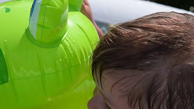 孩子在室外游泳池和橡胶蛙洗澡视频素材
