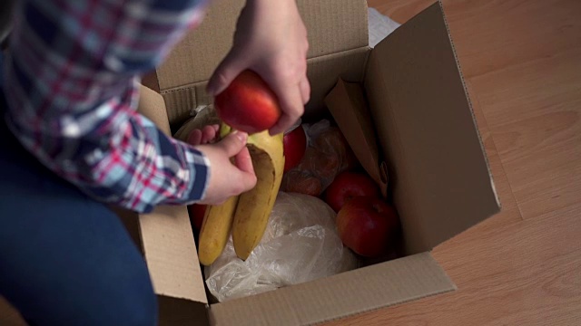 一个女人在家里打开一个食品快递盒视频素材