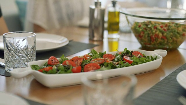 服务员把新鲜的时令沙拉和其他健康的菜肴放在碗里。视频素材
