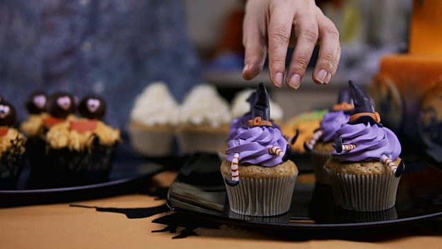 用糖衣帽和腿装饰纸杯蛋糕。松饼像女巫。万圣节的概念视频素材