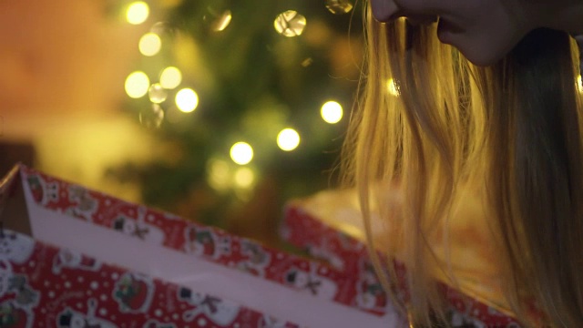 一位年轻女士正在打开圣诞礼物视频素材