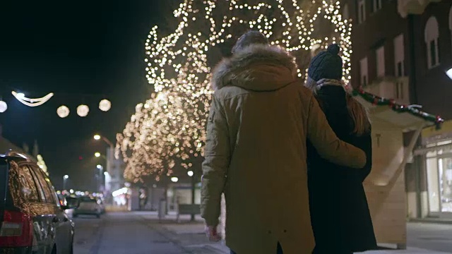 一对夫妇在圣诞节时走在城市的街道上视频素材