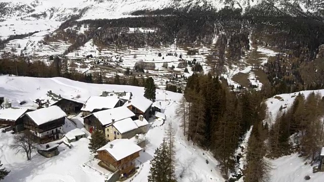 冬季无人机建立在雪山下的城镇和森林森林山谷。雪山在户外自然。飞行。旅行探索阿尔卑斯山，4k俯视图视频视频素材